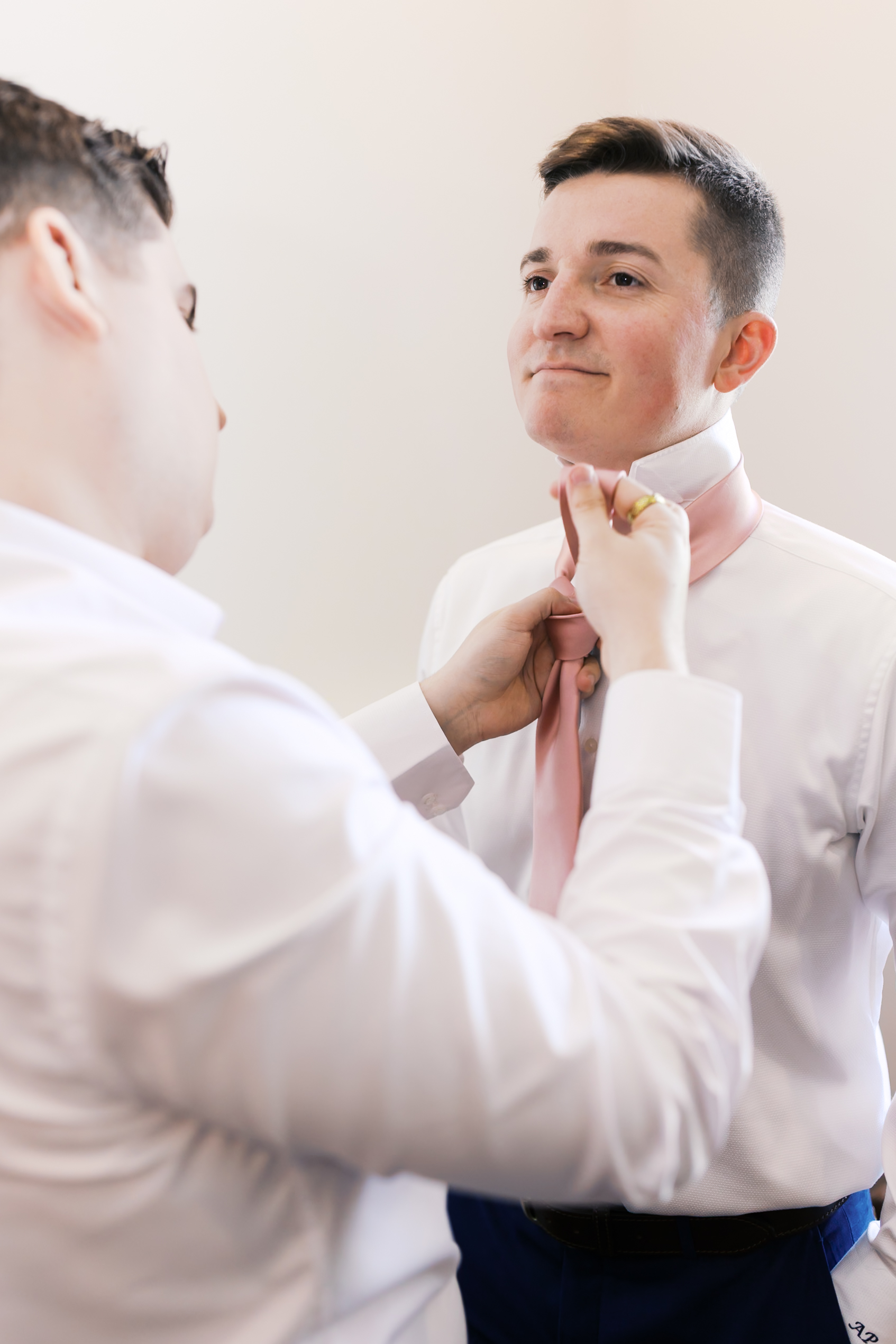 Groom's tie being adjusted while getting ready for his wedding at The Loretto.