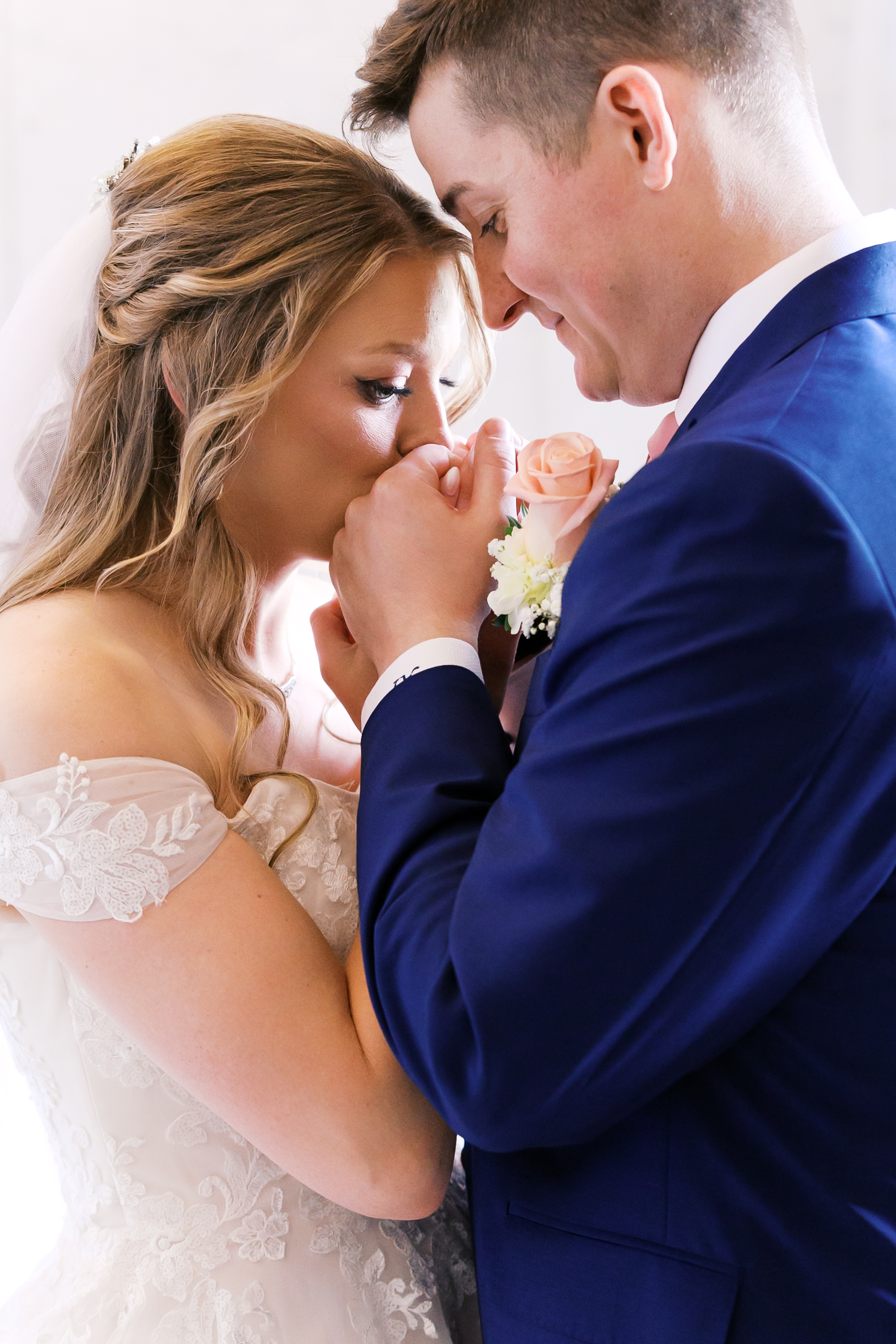 Groom kissing the bride's hand during an intimate first look portrait.