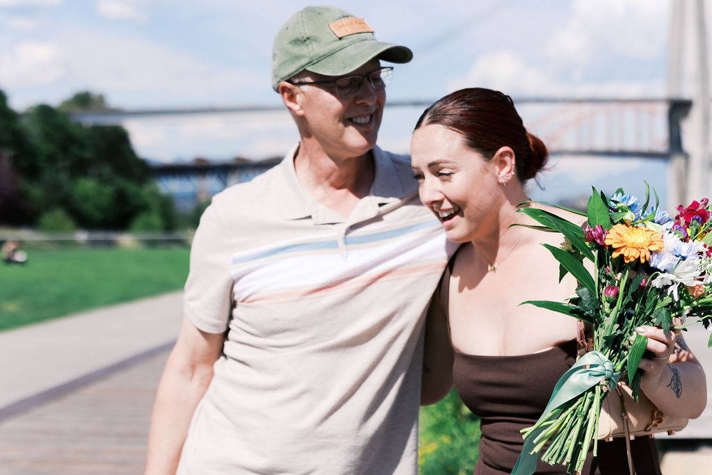 A family member walks with the newly engaged person while they carry a colorful bouquet.