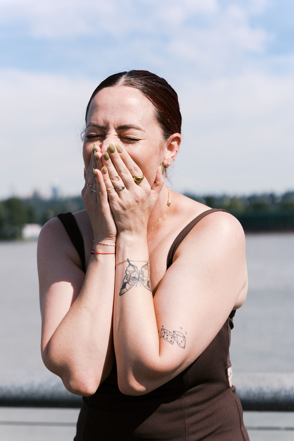 Close-up of the newly engaged person covering their face while reacting to the surprise.